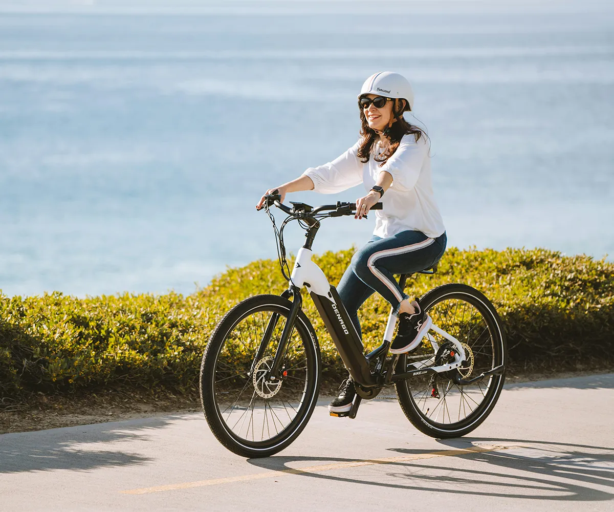 Two e-cyclists on a tour beside an e-bike charging station